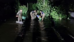 Rescuers help people to be evacuated from a flooded area after a Russian missile hit a hydraulic structure, amid Russia's attack on Ukraine, in Kryvyi Rih, Ukraine, in this handout picture released September 15, 2022. 