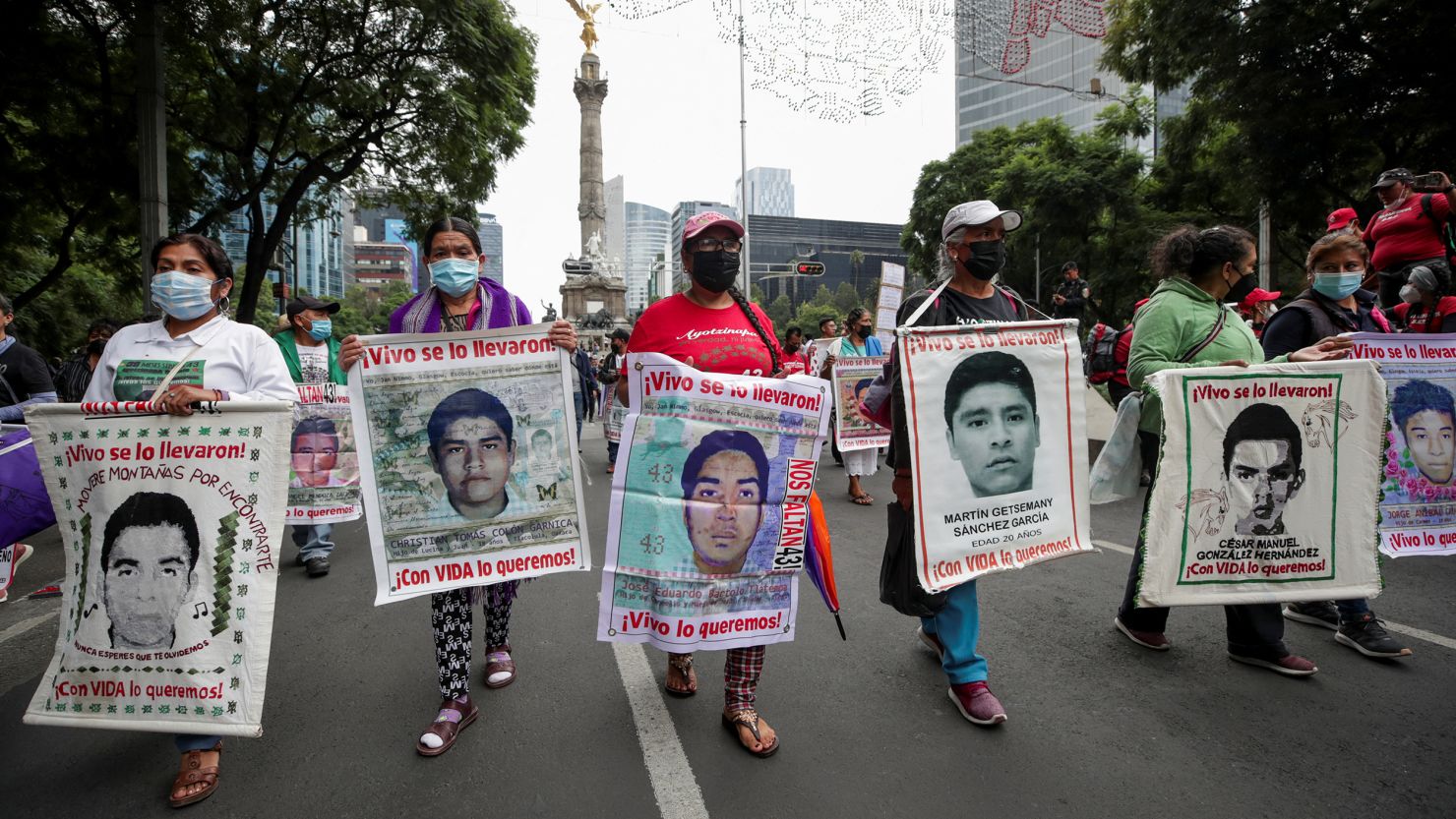 Relatives hold banners with images of the missing students from Ayotzinapa Teacher Training College, as they take part in a march to demand justice for their loved ones along Reforma avenue, in Mexico City, Mexico, August 26, 2022. 