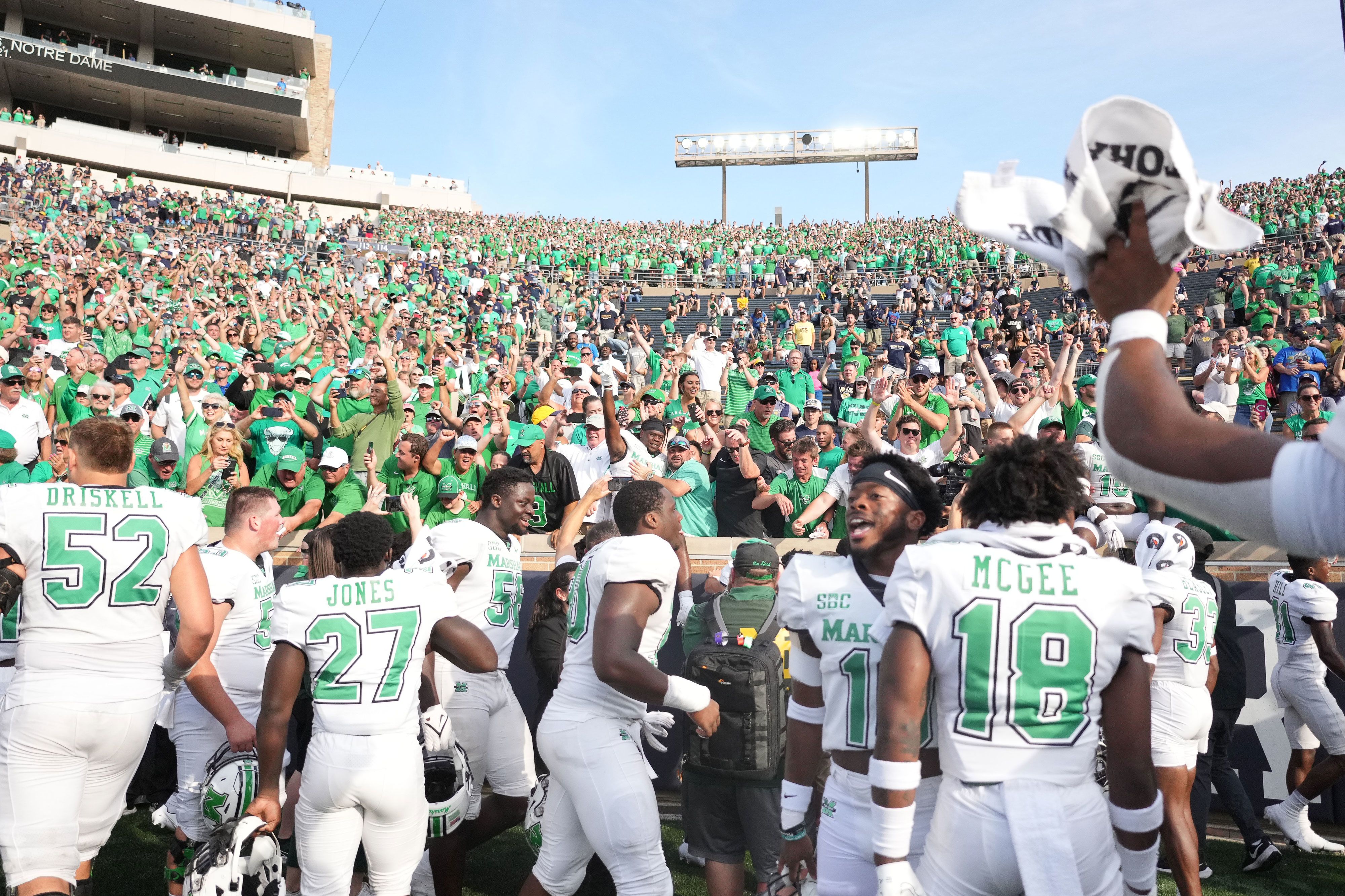 Marshall football players celebrate with fans after upsetting No. 8 Notre Dame 26-21 on Saturday, September 10.