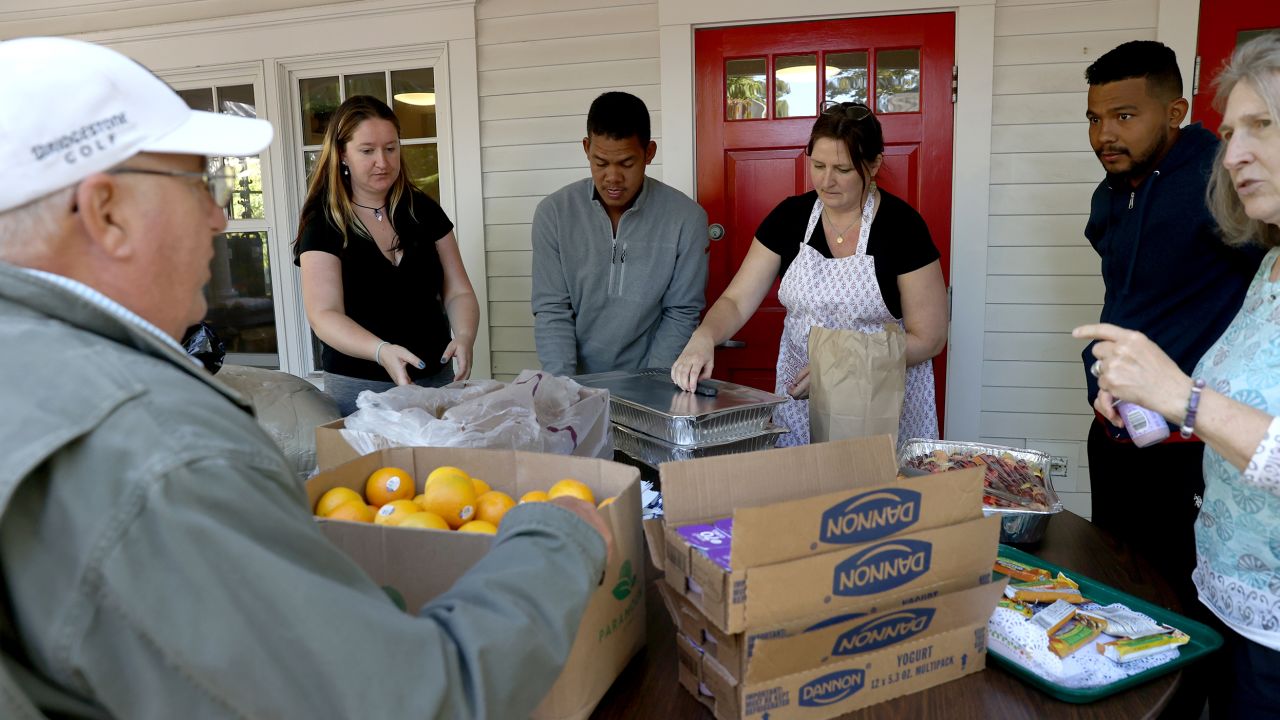 Volunteers help serve food to the recently arrived migrants.