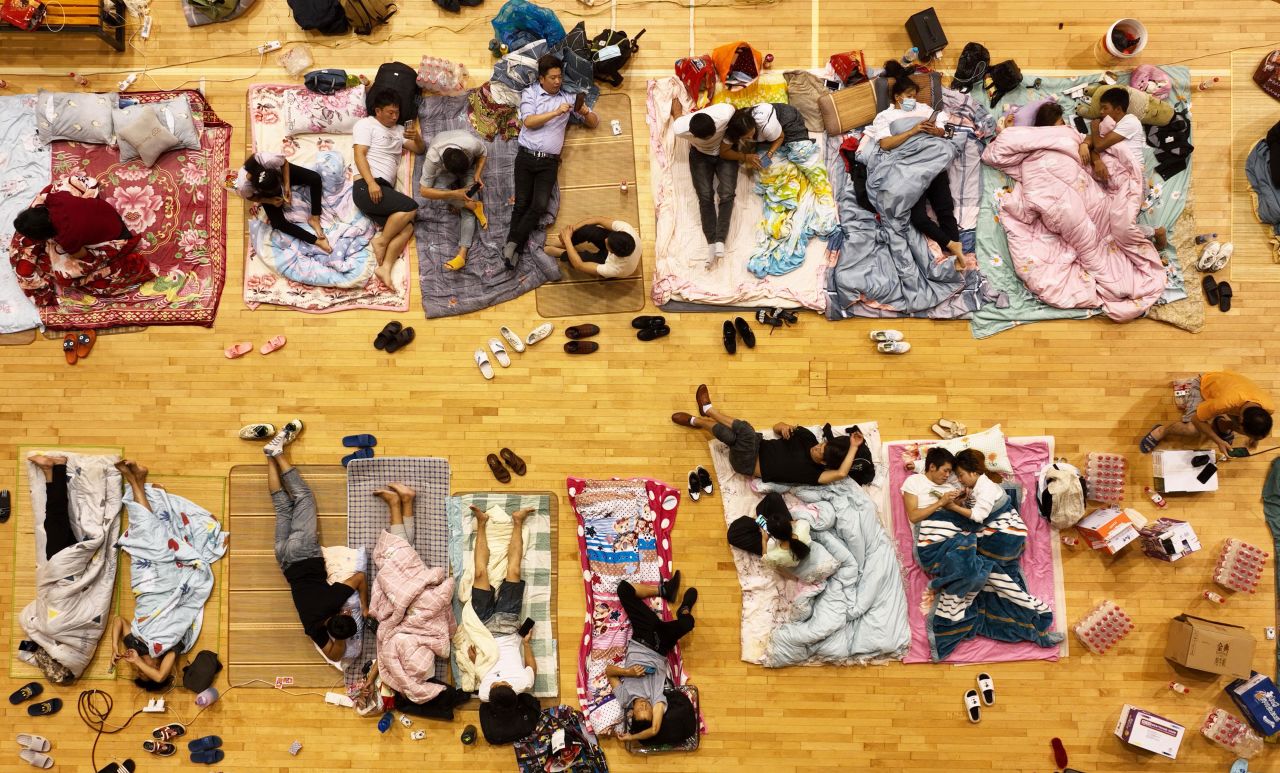 Migrant workers in Zhoushan, China, sleep on the floor of a basketball arena to avoid Typhoon Muifa on Tuesday, September 13. Muifa, the most powerful typhoon of the season so far, <a href=