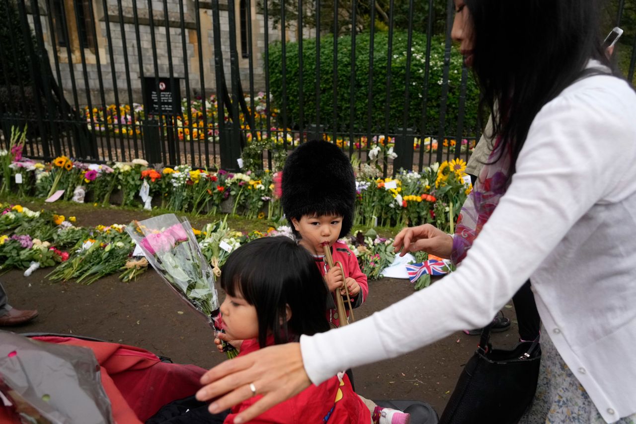 Sachiko Suckling and her 3 year-old twins, Naomi and Louis, lay flowers outside Windsor Castle on Thursday.