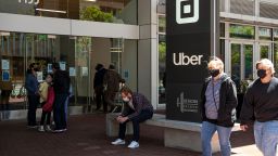 People wear protective masks in front of Uber Technologies Inc. headquarters in San Francisco, California, U.S., on Wednesday, June 9, 2021. California officials plan to fully reopen the economy on June 15, if the pandemic continues to abate, after driving down coronavirus case loads in the most populous U.S. state. Photographer: David Paul Morris/Bloomberg via Getty Images