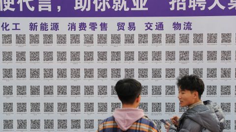 Estudiantes universitarios escanean códigos QR para buscar oportunidades laborales durante una feria de trabajo en la Universidad de Ciencia y Tecnología de Shandong el 16 de noviembre de 2021 en Qingdao, provincia china de Shandong. 