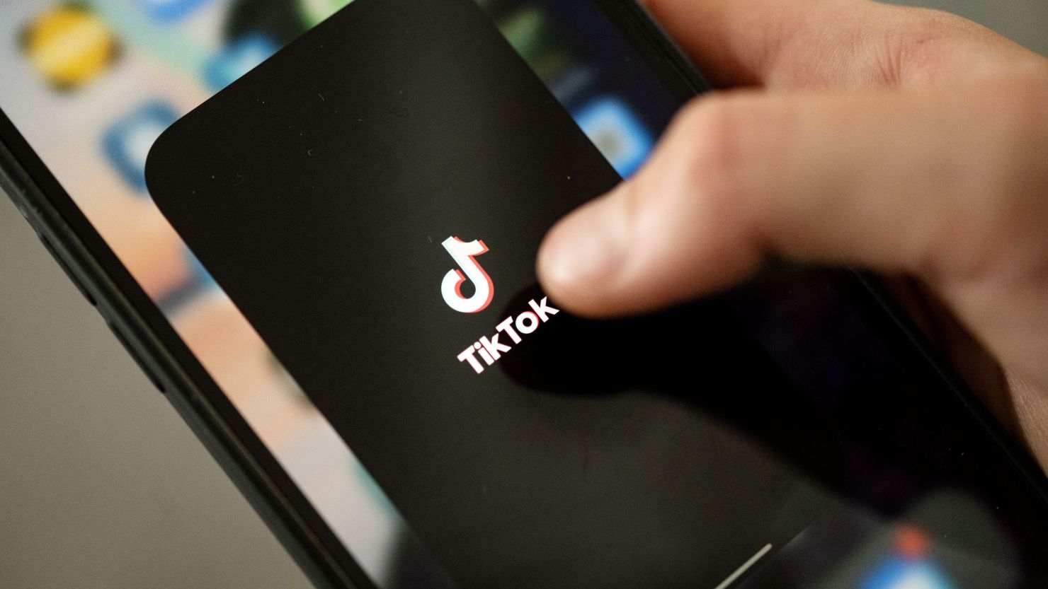 A teenager taps the TikTok logo on a smartphone. A research report this week says nearly 20% of videos presented by TikTok's search engine contain misinformation on topics ranging from Covid-19 to the January 6, 2021 insurrection. 