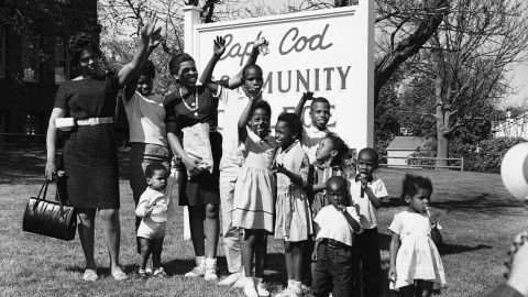 Victoria Bell, left, and her 11 children who arrived in Hyannis, Mass., on a trip sponsored by a White segregationist group in Little Rock, Arkansas, wave from the lawn of Cape Cod Community College, where they were housed temporarily in a dormitory, on May 22, 1962.