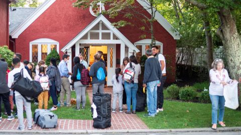 Venezuelan migrants stand outside St. Andrew's Church in Edgartown, Massachusetts, on September 14, 2022.
