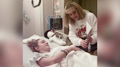 Missy Jenkins looks at a recovery card with her twin sister, Mandy, at a Kentucky hospital in 1997. 