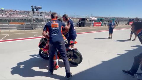 The mechanics try to interfere with bike as it attempts to leave.
