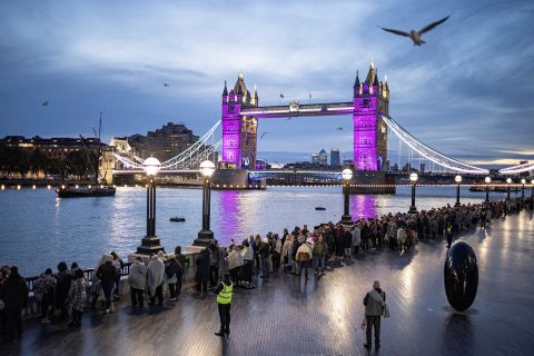 People wait in line near London's Tower Bridge for a chance to pay their respects to the Queen.