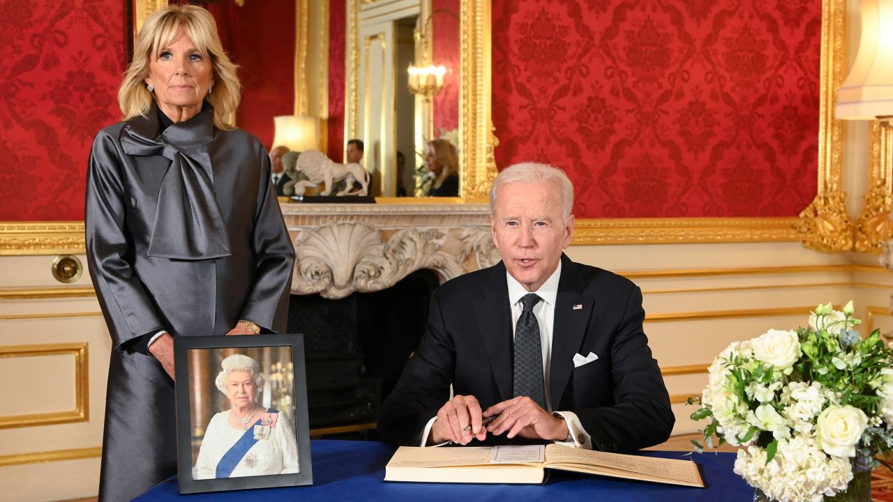 President Joe Biden, accompanied by first lady Jill Biden, signs a condolence book at Lancaster House in London.