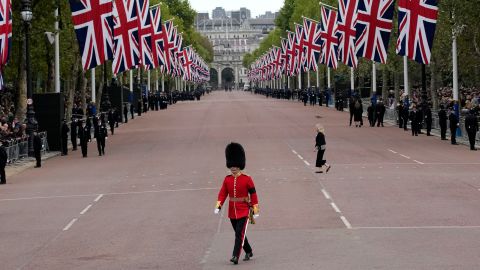 A King's Guard soldier crosses The Mall outside Buckingham Palace before the funeral begins.