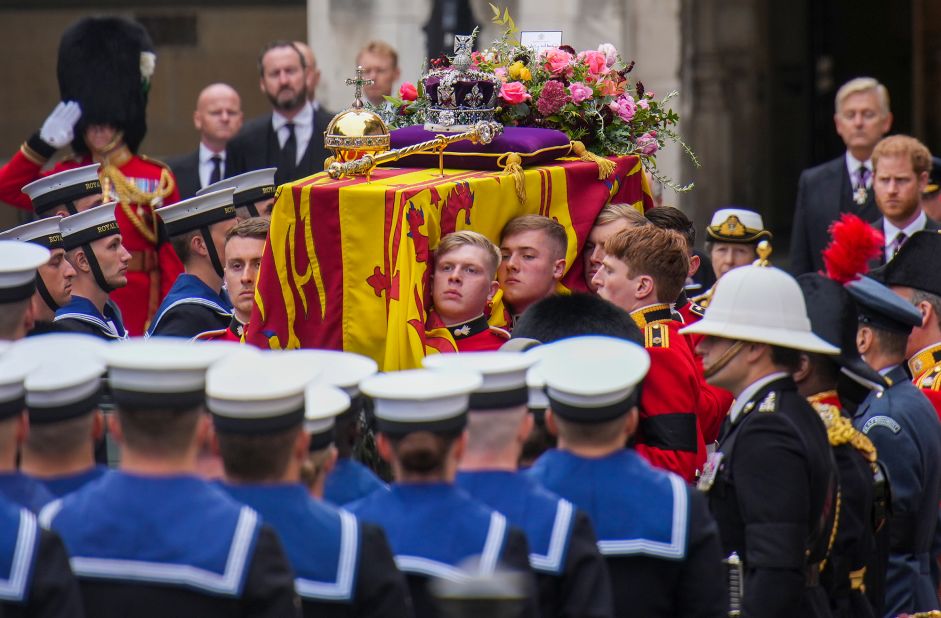 The coffin is carried into Westminster Abbey after a short procession from Westminster Hall, where the Queen was lying in state. The coffin was draped with the Royal Standard, and the Instruments of State -- the Imperial State Crown and regalia -- <a href="https://www.cnn.com/uk/live-news/funeral-queen-elizabeth-intl-gbr/h_62df63a1713d7b8828a217117d826d9c" target="_blank">were laid upon it</a> along with a flower wreath.