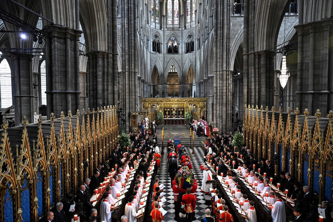 The Queen's coffin, draped in the Royal Standard, is carried inside Westminster Abbey.