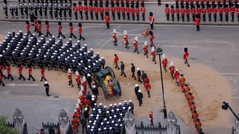 Members of the armed forces march alonside the Queen's coffin.