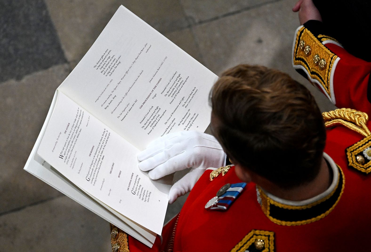 A guest reads the order of service during the funeral.