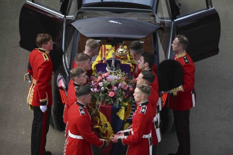 Pallbearers transfer the Queen's coffin into a hearse at London's Wellington Arch.