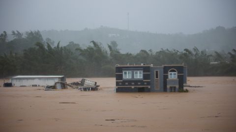 Uma casa afundada em um domingo em Caye, Porto Rico.  Três pessoas teriam sido resgatadas dentro da casa. 