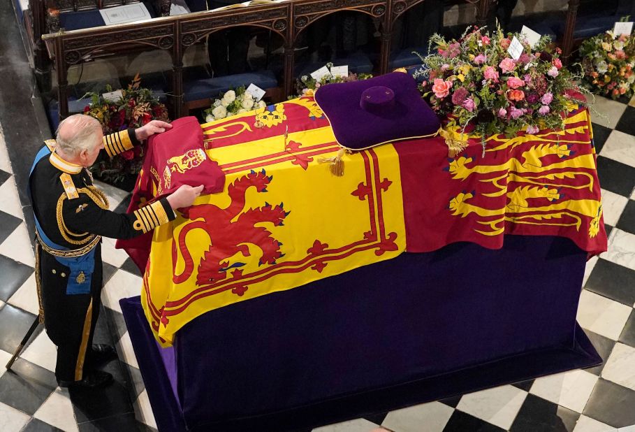 Britain's King Charles III places the Queen's Company Camp Colour of the Grenadier Guards on the coffin of his mother, Queen Elizabeth II, during a committal service at St. George's Chapel in Windsor Castle on Monday, September 19.
