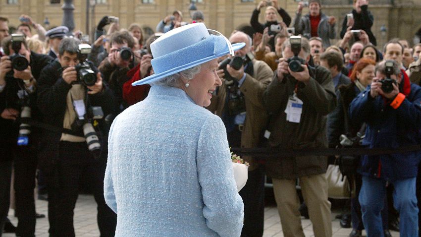 TOPSHOT - Press photographers snap pictures of Queen Elizabeth II outside the Louvre museum in Paris, where she viewed paintings which will form part of the new British Gallery due to open in 2005, 06 April 2004, on the second day of a three-day state visit to mark the centenary of the Entente Cordiale, the colonial-era promise of cross-channel friendship between Britain and France. (Photo by JOEL SAGET / AFP) (Photo by JOEL SAGET/AFP via Getty Images)