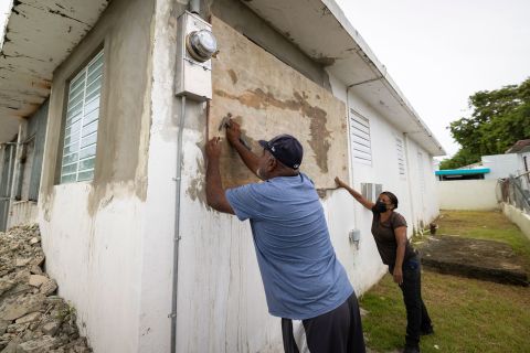 Residents attach protective plywood to a window of their home in preparation for the arrival of Fiona in Loíza Saturday.