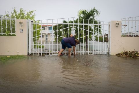 A woman clears debris on her flooded property in Salinas on Monday.