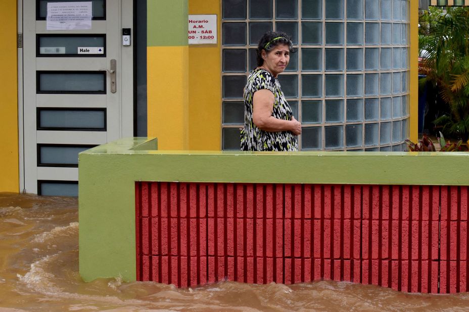 A woman stands outside her flooded house in Salinas on Monday.