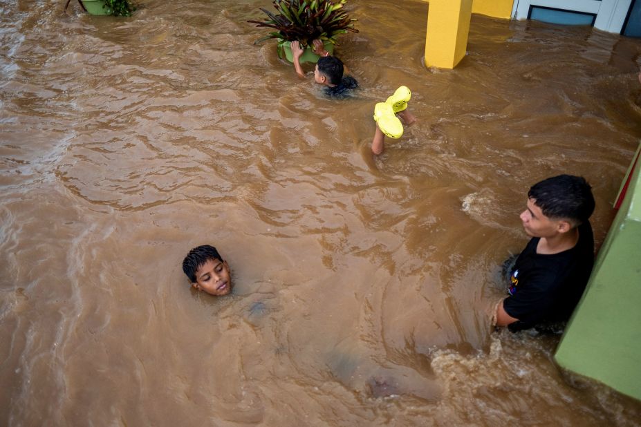 Children swim in a flooded street in Salinas on Monday.