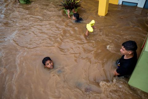 Trẻ em chơi trên một con phố ngập lụt sau hậu quả của Fiona ở Salinas hôm thứ Hai.