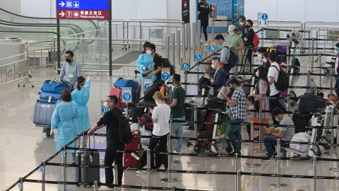 Travelers at Hong Kong International Airport wait in line for shuttle buses to their quarantine hotels in August 2022.