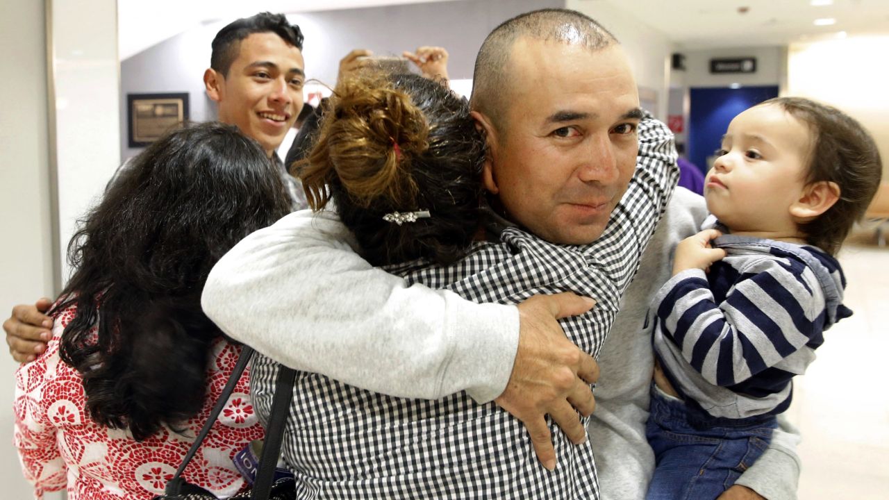 In this Nov. 12, 2015, photo, Gabriel Mejia hugs his daughter Wendy, 16, as he holds his son Elias, 1, after her arrival from El Salvador at Baltimore-Washington International Airport in Linthicum, Md. Pictured at back left is his son Brian, 19. After 15 years apart, Mejia reunited with his children, some of the first teenagers to be granted refugee status and permission to travel legally to the United States through the State Department's Central American Minor program. (AP Photo/Patrick Semansky)