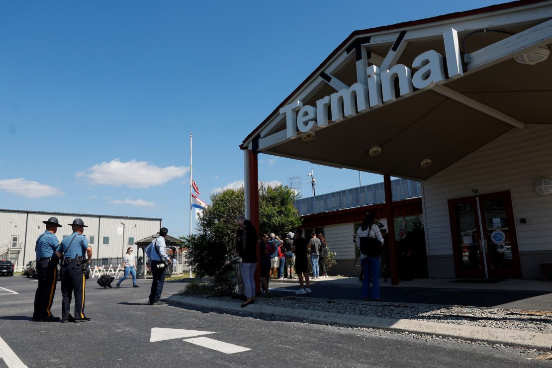 People gather outside of Delaware Coastal Airport on Tuesday in the wake of reports suggesting migrants will arrive there on a plane from Texas.