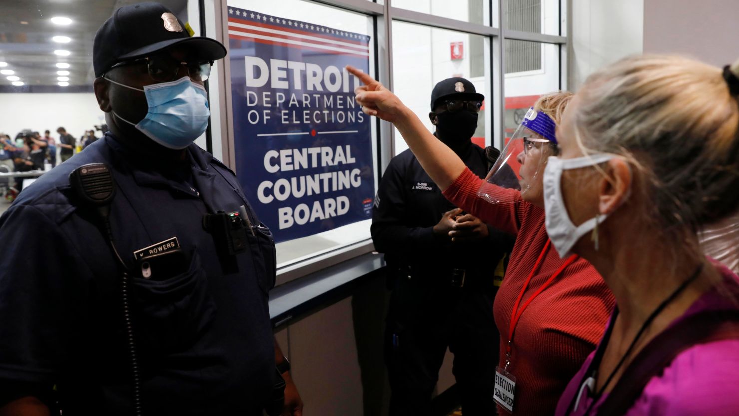Police officers stand facing supporters of US President Donald Trump as they chant slogans outside the room where absentee ballots for the 2020 general election are being counted at TCF Center on November 4, 2020 in Detroit, Michigan.