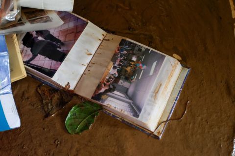 A photo album belonging to Luis Ramos Rosario lies in the mud inside his home after it was flooded by Hurricane Fiona in Cayey, Puerto Rico.