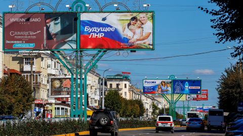 Vehicles drive past advertising boards displaying pro-Russian slogans in a street in Luhansk, Ukraine, on September 20. 