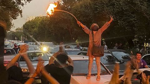 A woman sets her hijab on fire during a protest in central Tehran.