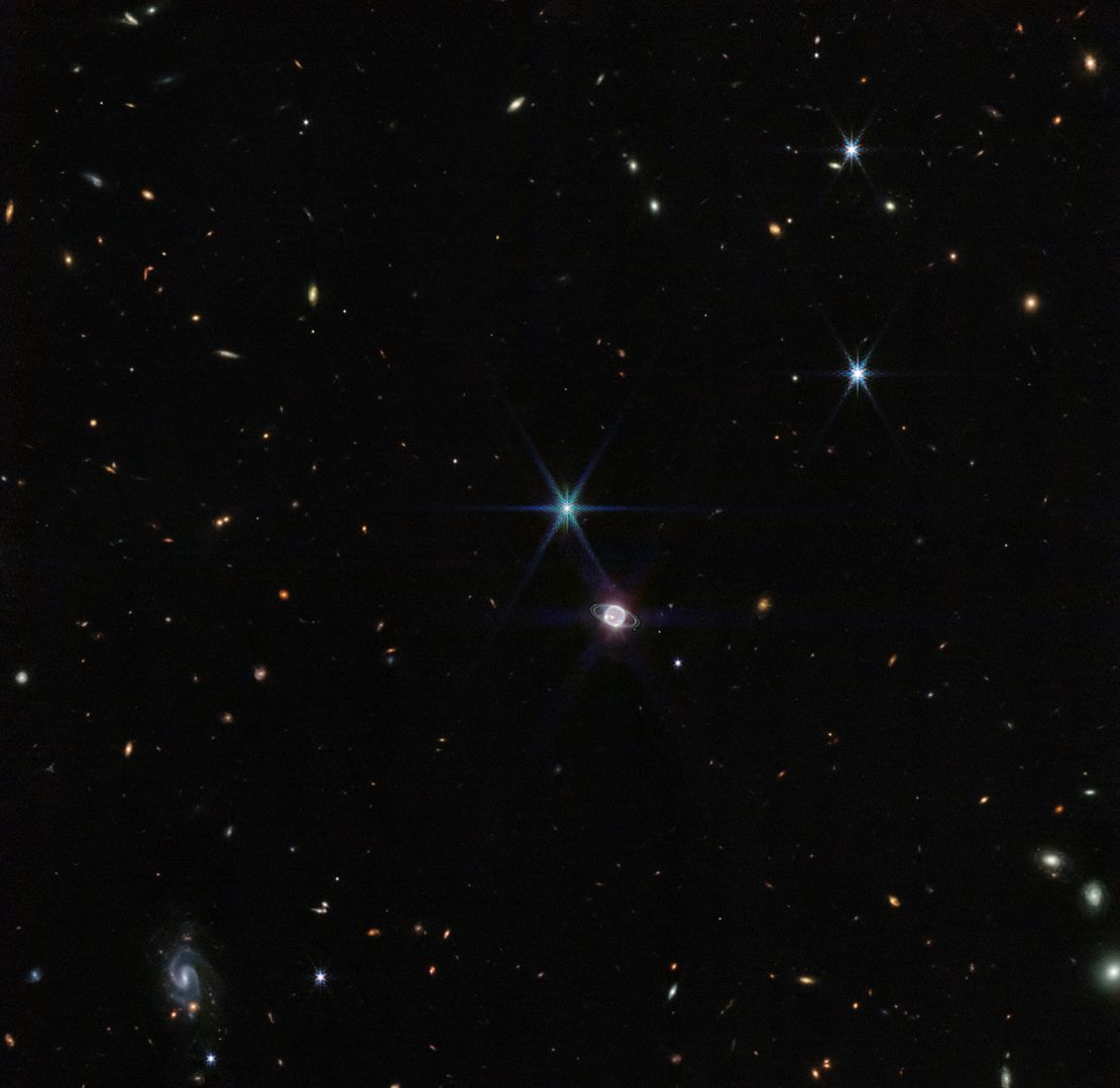 In this image by Webb's Near-Infrared Camera, a smattering of hundreds of background galaxies, varying in size and shape, appear alongside Neptune.