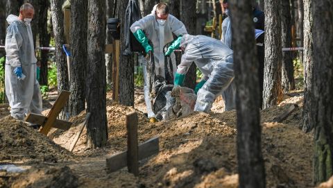 Forensic technicians operate at the site of a mass grave in a forest on the outskirts of Izyum, eastern Ukraine on September 18. Ukrainian authorities discovered hundreds of graves outside the formerly Russian-occupied city.
