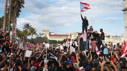 Rapper Bad Bunny (holding flag), Ricky Martin (black hat) and rapper Residente (blue hat) join demonstrators protesting against Ricardo Rosselló, the Governor of Puerto Rico who was ousted after massive protests in Puerto Rico in 2019.