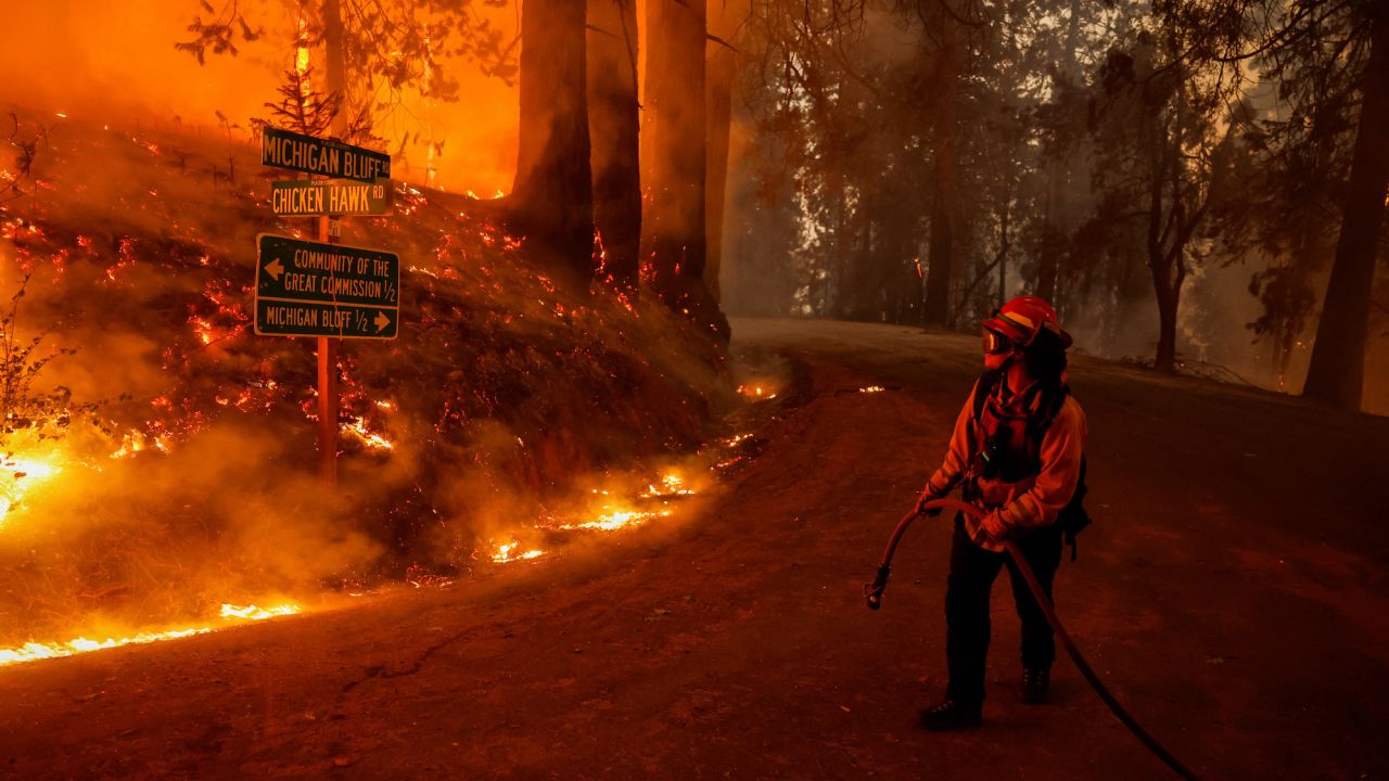 A firefighter monitors flames from the Mosquito Fire as it burns in Foresthill in Placer County, California, U.S., September 7, 2022. REUTERS/Fred Greaves