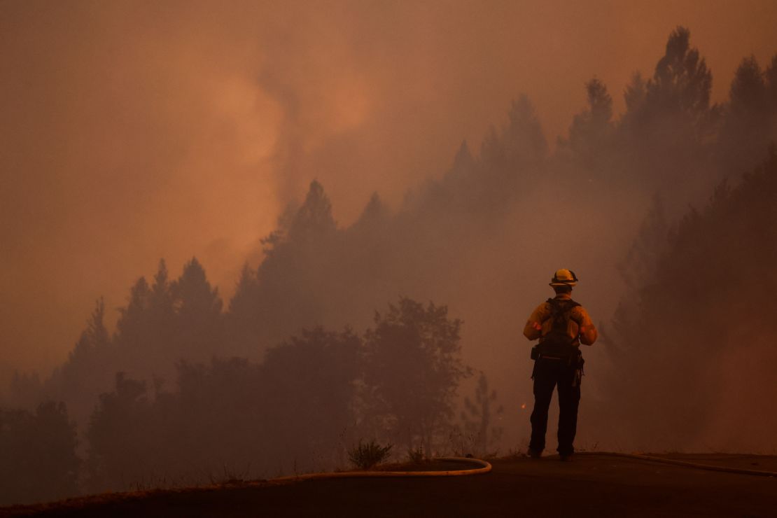 A firefighter watches the Mosquito Fire while protecting structures on September 13.