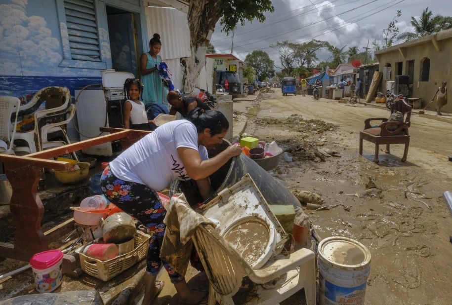 Residents work to recover belongings after flooding in the Los Sotos neighborhood of Higuey on Tuesday.