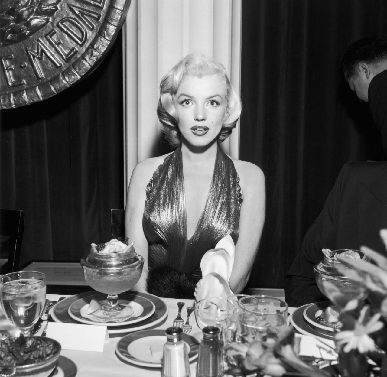 Monroe  sits at a banquet table during a Photoplay Gold Medal Awards dinner in the 1950s.