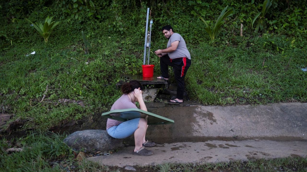 A man collects spring water Wednesday at a mountain next to a highway in the aftermath of Hurricane Fiona in Cayey, Puerto Rico
