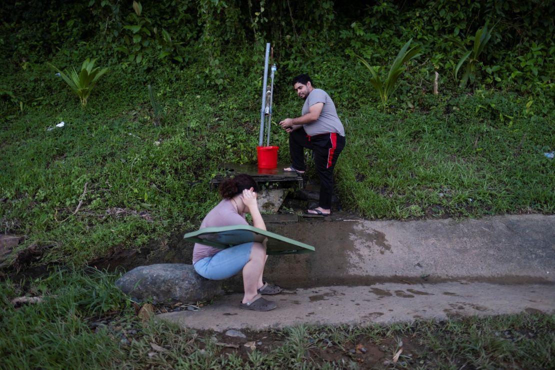 A man collects spring water Wednesday at a mountain next to a highway in the aftermath of Hurricane Fiona in Cayey, Puerto Rico