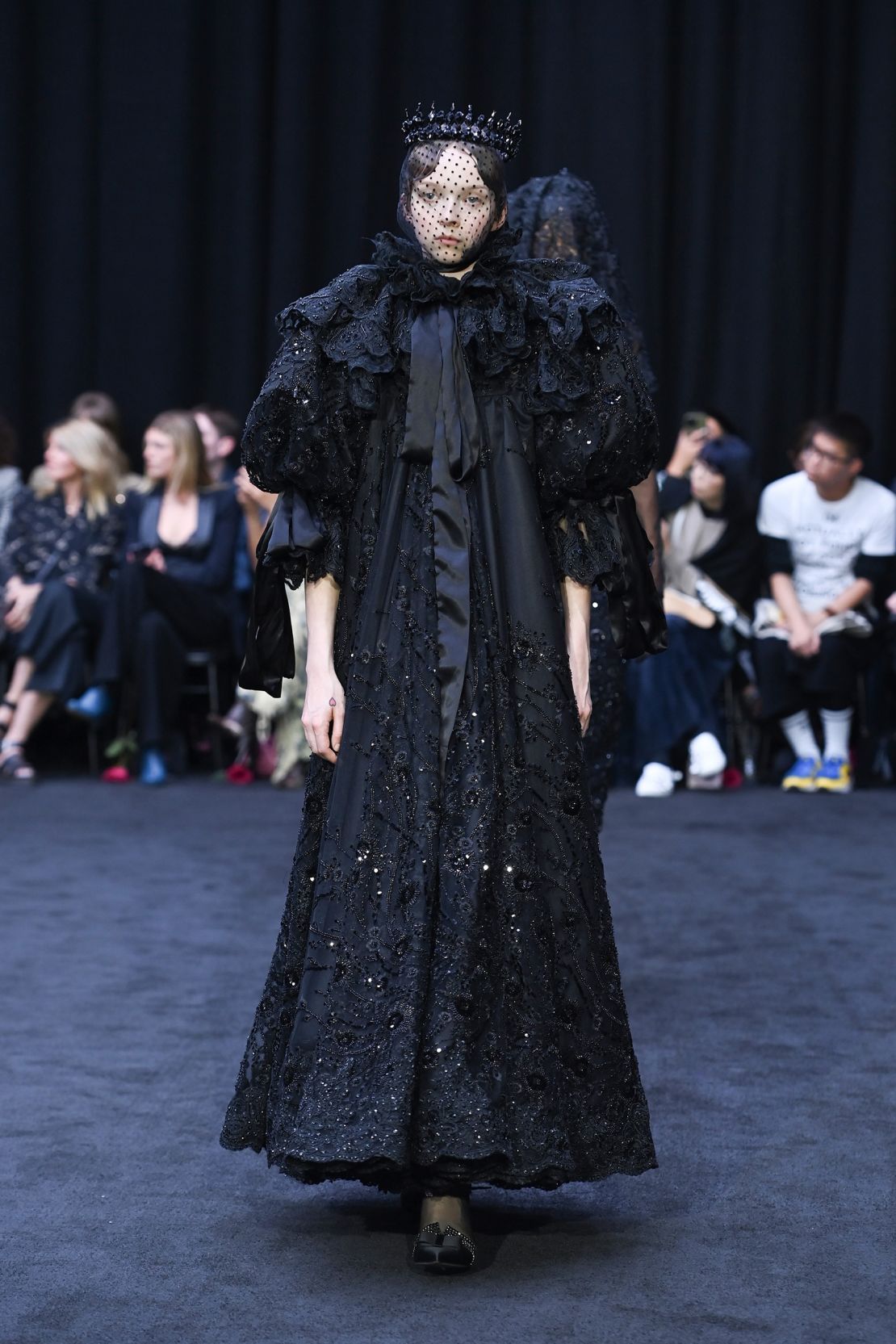 The first half of Richard Quinn's Spring-Summer 2023 show resembled a funeral procession: all-black, regal-inspired looks.
