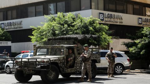 جنود الجيش اللبناني يؤمنون المبنى القريب من أحد البنوك في بيروت بعد أن اقتحم مودع الفرع مطالبته بالحصول على أمواله.