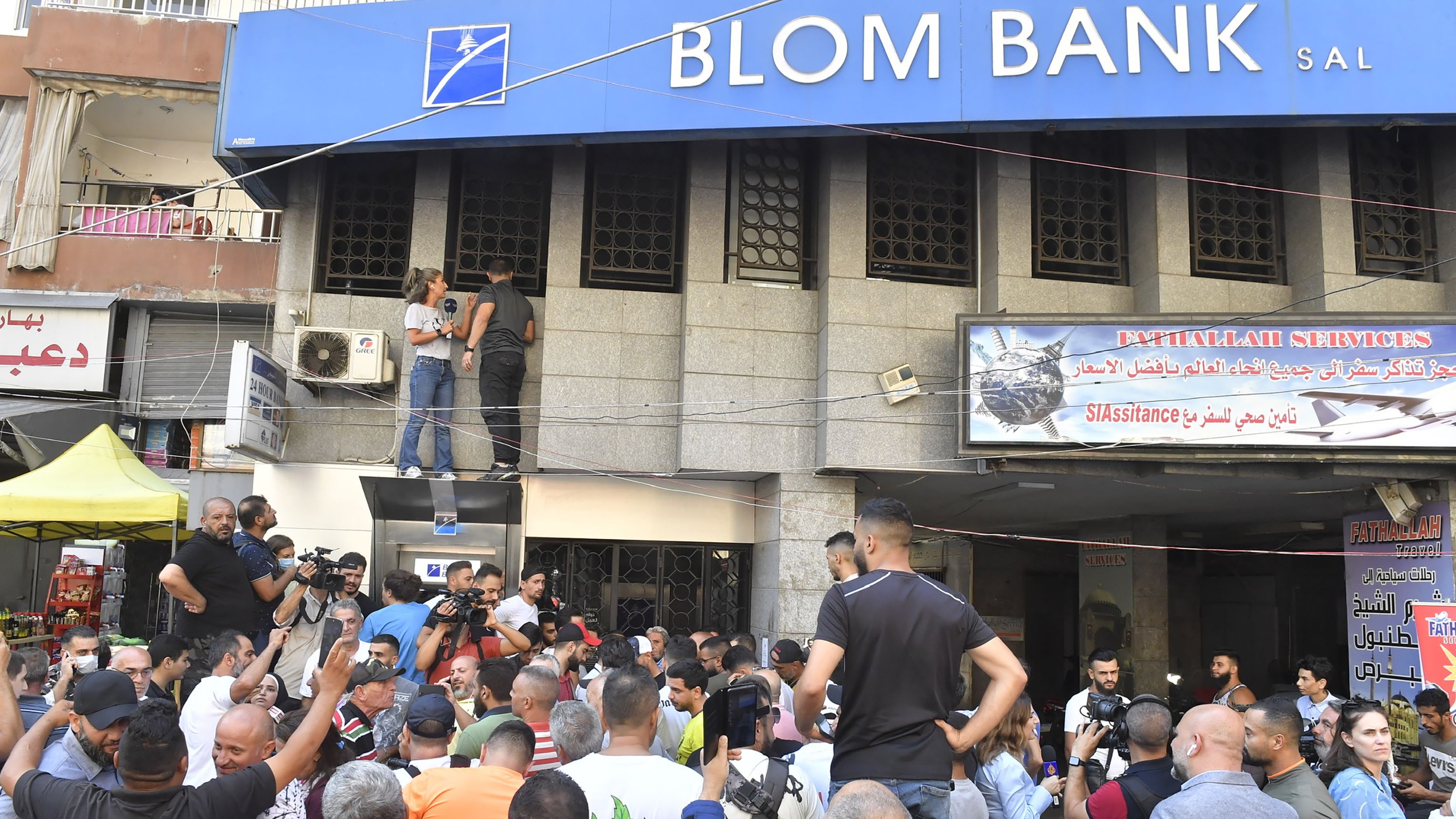 Lebanese people rally in support of a man who entered a bank to protest demanding his savings in Beirut on September 16, 2022.