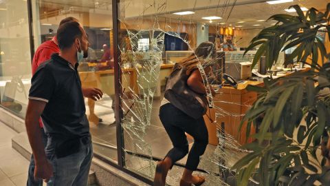 The glass window of a bank is broken after a woman stormed it on September 14.