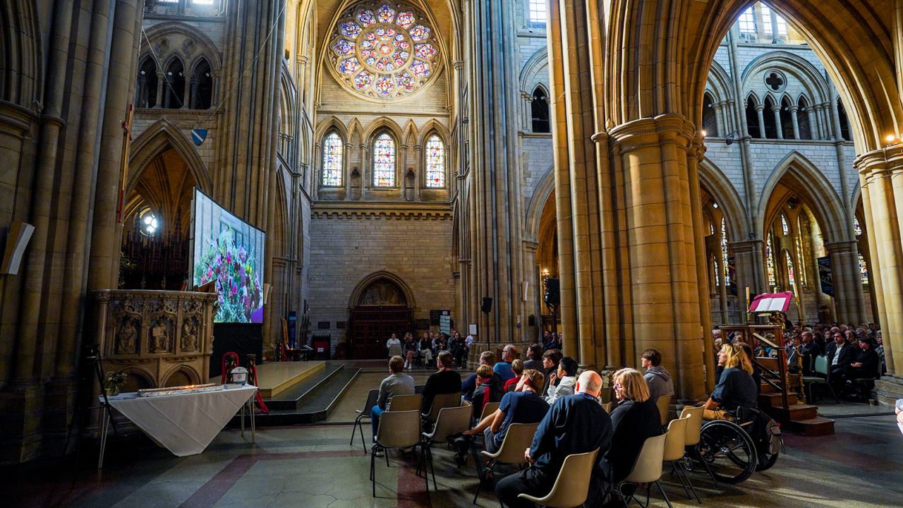 Members of the public watch the funeral at the cathedral in Truro, England.